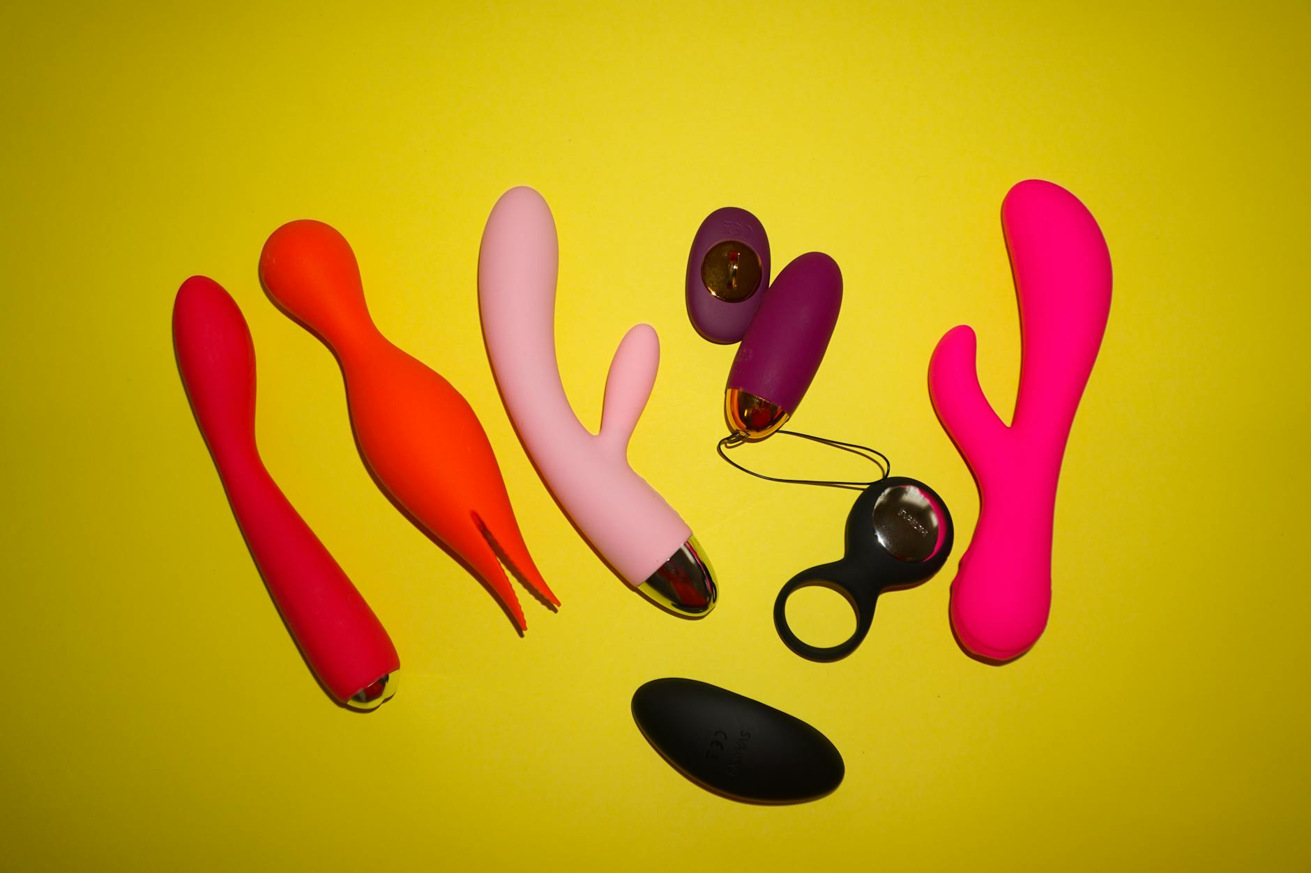 Colorful vibrators on a bright yellow background, showcasing diverse designs and options